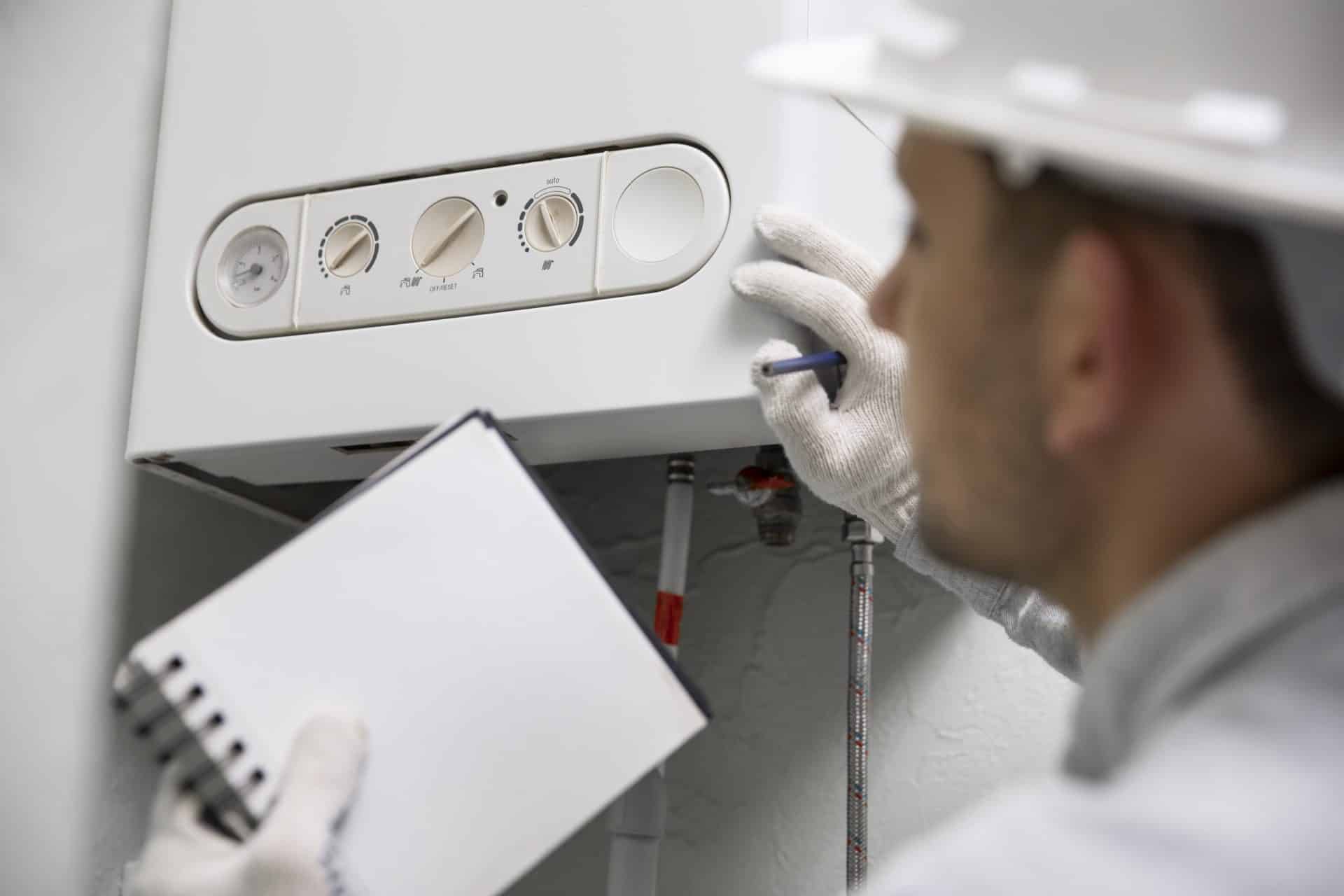worker repairing water heater <strong>How Long Does It Take to Fit a Boiler</strong>